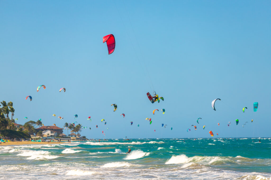 Windsurfing at Kite Beach in Cabarete" and "Surfer enjoying waves at Bozo Beach in Cabarete.