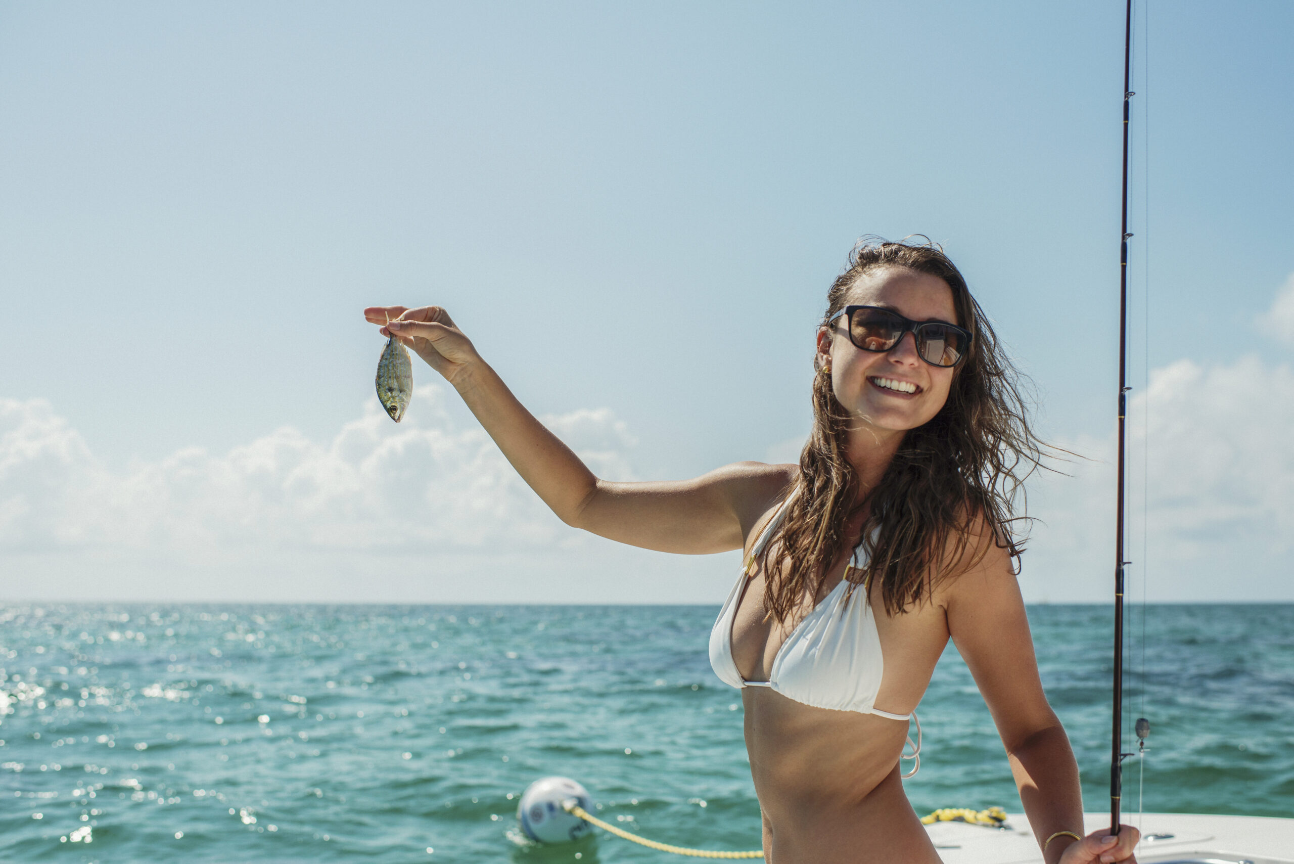 Woman holding a fish on a boat in Cabarete